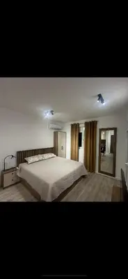 a bedroom with a large bed and a mirror at Apartmani Kralj Bar in Bar