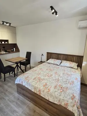 a bedroom with a bed and a table with chairs at Apartmani Kralj Bar in Bar