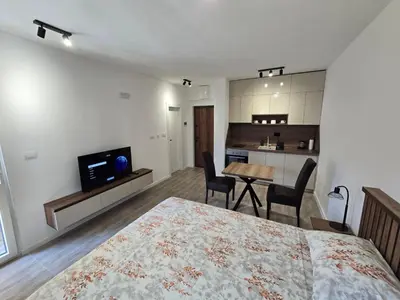a bedroom with a bed and a table and chairs at Apartmani Kralj Bar in Bar