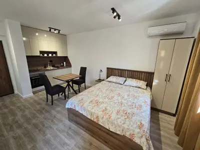 a bedroom with a bed and a table with chairs at Apartmani Kralj Bar in Bar