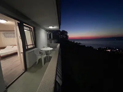 a balcony with a view of the ocean at night at Apartman MK in Kruče