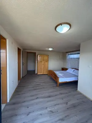 an empty room with a bed and a ceiling at Apartman MK in Kruče