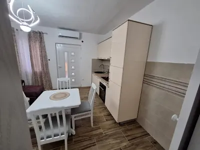 a small kitchen with a table and a white refrigerator at Dejana Apartments in Kotor