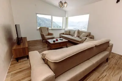 a living room with a couch and chairs and windows at Dejana Apartments in Kotor