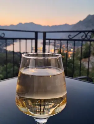a glass of wine sitting on top of a table at Dejana Apartments in Kotor