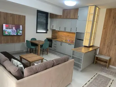 a living room with a couch and a table and a kitchen at Flamur Ujkashi in Ulcinj