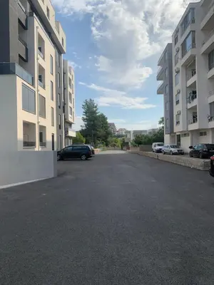 an empty parking lot between two apartment buildings at Flamur Ujkashi in Ulcinj