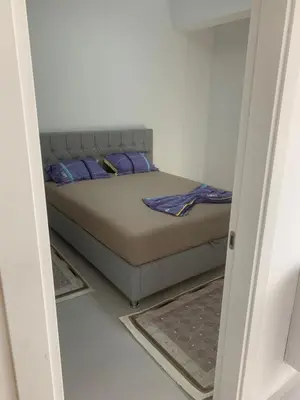 a bed with purple pillows in a small room at Flamur Ujkashi in Ulcinj