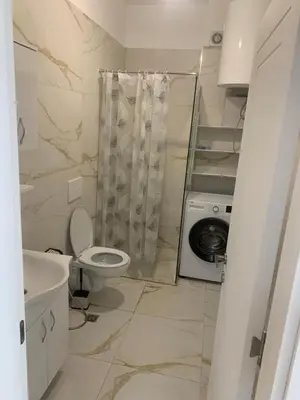 a bathroom with a toilet and a washing machine at Flamur Ujkashi in Ulcinj