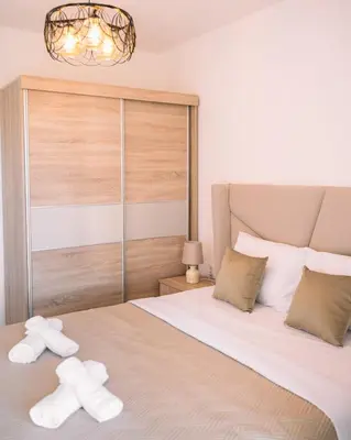a bedroom with a bed with two white towels on it at Royal Apartment in Ulcinj