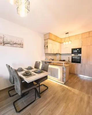 a kitchen with a table and chairs in a room at Royal Apartment in Ulcinj