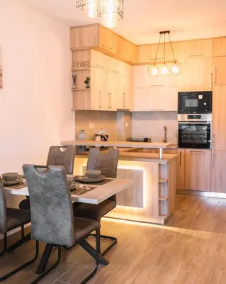 a kitchen with a table and chairs in a room at Royal Apartment in Ulcinj