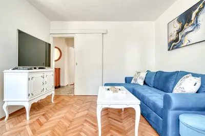 a living room with a blue couch and a tv at Apartment Seaside in Kotor