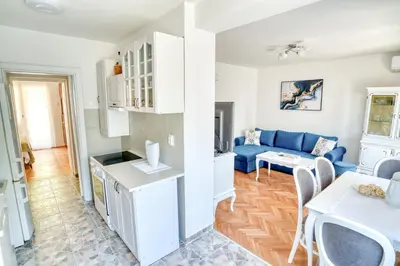 a kitchen and living room with a blue couch at Apartment Seaside in Kotor