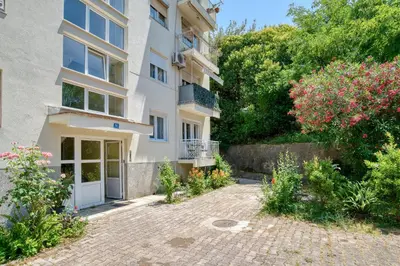 an apartment building with a courtyard with flowers at Apartment Seaside in Kotor
