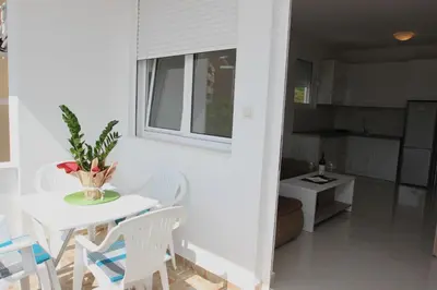 a small white table and chairs in a kitchen at Guest House Ugljevarevic in Budva