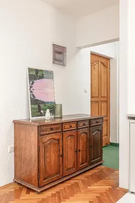 a wooden cabinet in a room with a door at Cozy Studio Budva in Budva