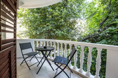 a patio with two chairs and a table on a balcony at Cozy Studio Budva in Budva