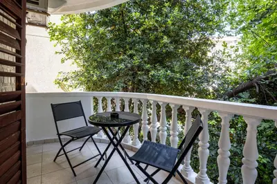 a patio with two chairs and a table on a balcony at Cozy Studio Budva in Budva