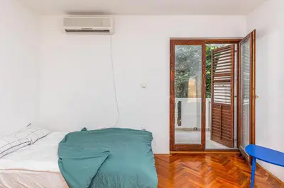 a bedroom with a bed and a window with a window at Cozy Studio Budva in Budva