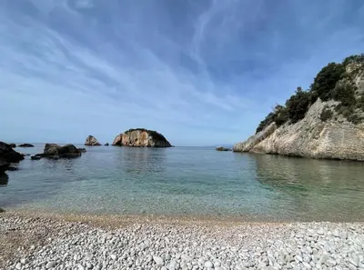 a rocky beach with a rock formation in the water at Apartments Dana Seaview in Bar