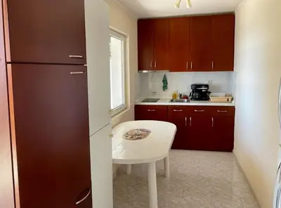 a small kitchen with a table and a refrigerator at Apartments Dana Seaview in Bar