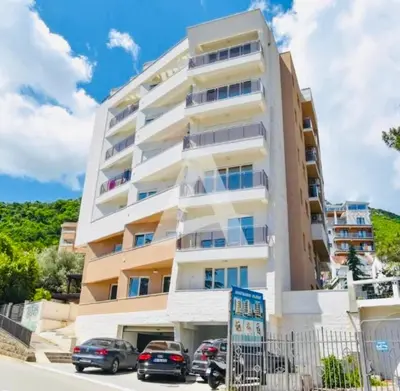 a building with cars parked in front of it at Boljevic Apartments in Becici