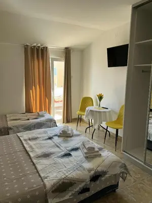 a bedroom with two beds and a table and chairs at Apartmani Jelenaa in Budva