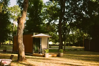 a small cabin with an umbrella in a park at Neptun Beach & Forest Cabins in Ulcinj