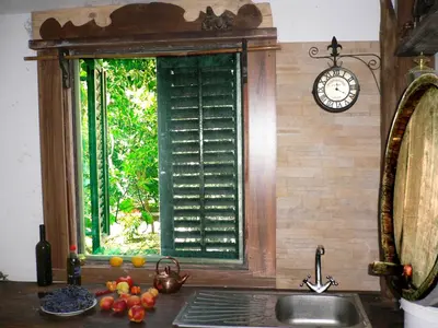 a window in a kitchen with a sink and a clock at villa Magnolia in Donji Štoj