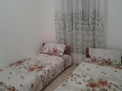 a bedroom with two beds and a curtain at villa Magnolia in Donji Štoj