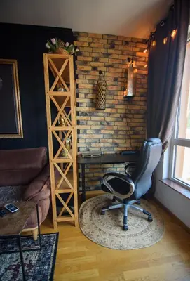 a chair in a room with a brick wall at Apartment with sea view 5 minutes from the beach in Budva