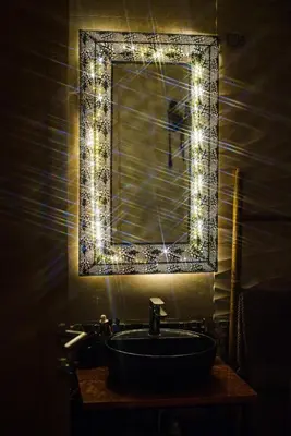 a bathroom with a mirror and a sink with lights at Apartment with sea view 5 minutes from the beach in Budva