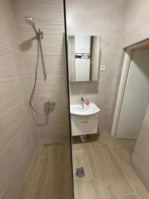 a bathroom with a sink and a shower with a mirror at Gio Bella in Sutomore