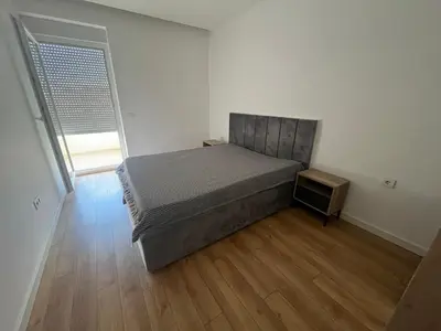 a bedroom with a bed and a wooden floor at Apartmants Taco Ulcinj in Ulcinj