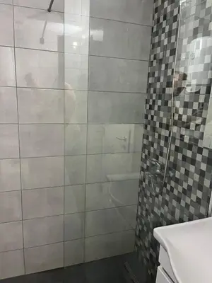a bathroom with a glass shower with a sink at Apartmants Taco Ulcinj in Ulcinj