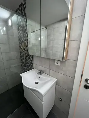 a bathroom with a white sink and a mirror at Apartmants Taco Ulcinj in Ulcinj