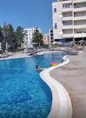 a person swimming in a pool next to a beach at Apartmants Taco Ulcinj in Ulcinj