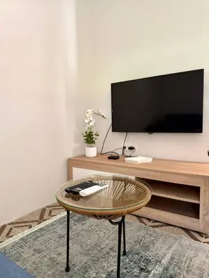 a living room with a desk with a tv and a chair at Tatjana apartman blue in Sutomore