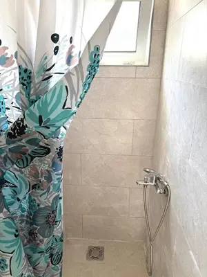 a shower with a shower curtain in a bathroom at Tatjana apartman blue in Sutomore