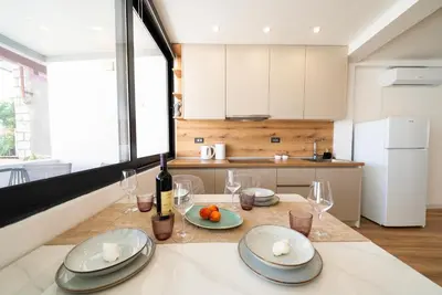 a kitchen with a table with plates and wine glasses at Latković Charming Studio in Ulcinj