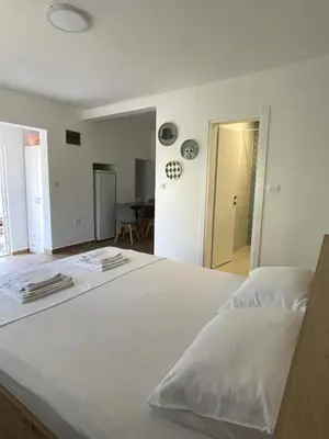 a large white bed in a room with a table at Apartmani Baila in Ðurmani