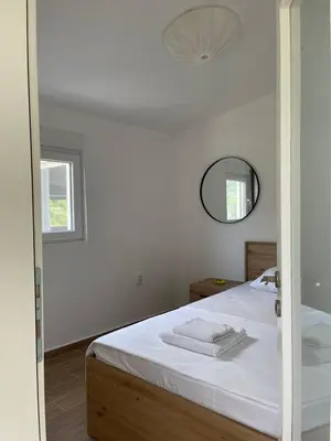 a bedroom with a white bed and a mirror at Apartmani Baila in Ðurmani