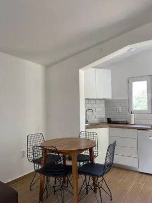 a kitchen with a table and chairs in a room at Apartmani Baila in Ðurmani
