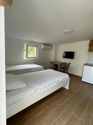 a bedroom with a white bed and a table at Apartmani Baila in Ðurmani