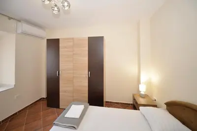 a bedroom with a bed and a cabinet in it at Kuzman Apartments in Kotor