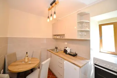 a kitchen with a wooden table and a sink at Kuzman Apartments in Kotor