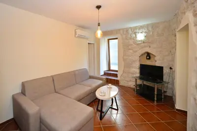 a living room with a couch and a tv at Kuzman Apartments in Kotor