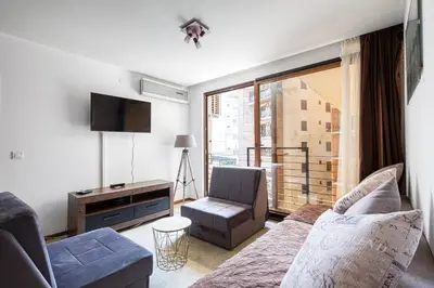 a living room with a couch and a chair and a window at Cihan Apartment in Budva