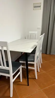 a white dining room table with four white chairs at Stanovi VR in Bar